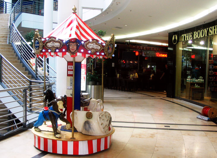 Das kleine Kinderkarussell als Blickfang und Attraktion in einem Shopping Center.